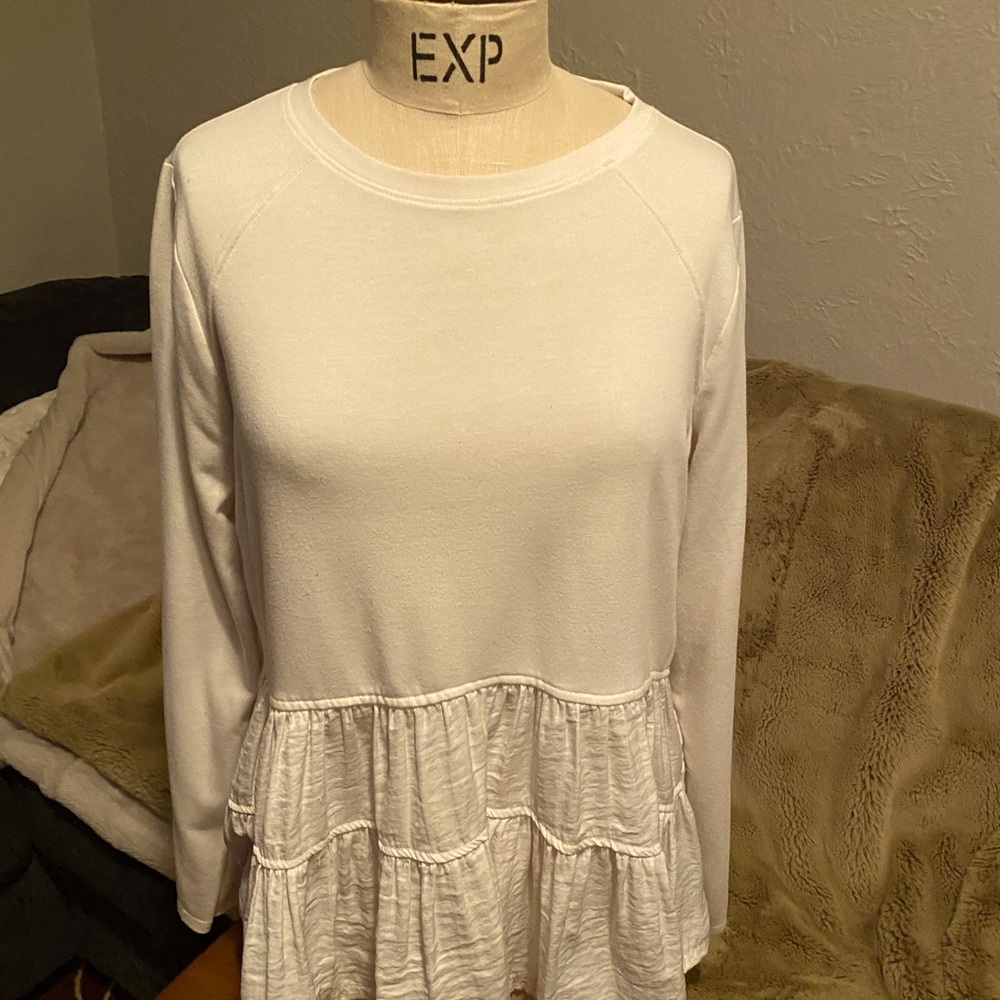 White long sleeve cotton tee with ruffle bottom.